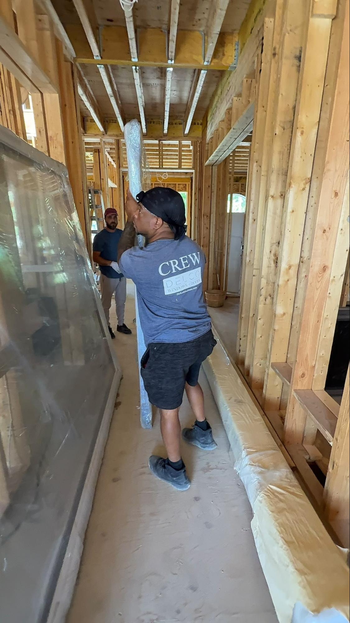 Delco Windows and Doors crew handling a window opening during a structural framing project