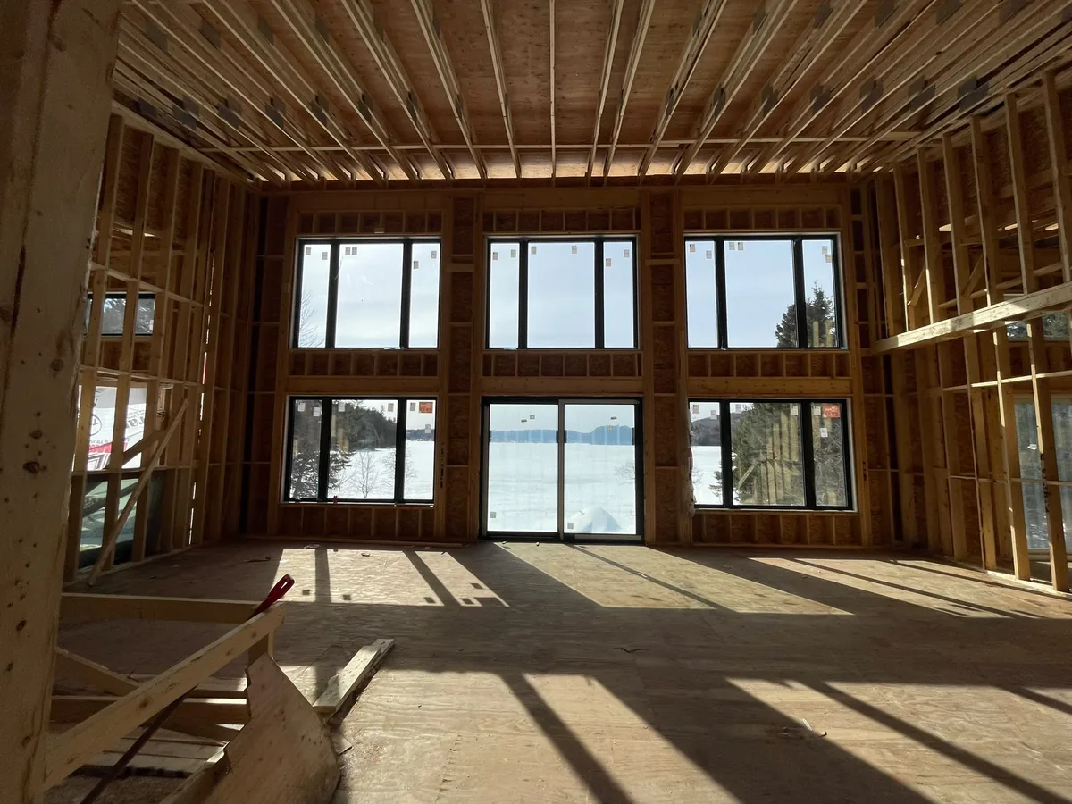 Sunlit new-build room with a large wall of new windows and a glass sliding door, double slider window installation in Toronto
