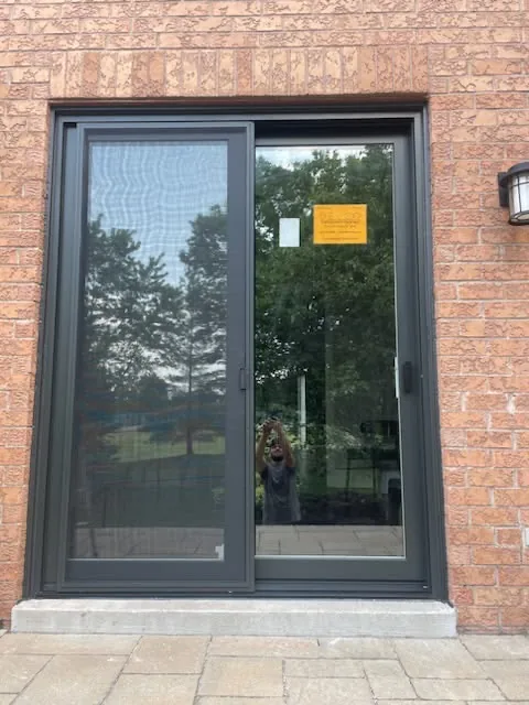 Black-frame sliding glass garden door newly installed in a red-brick wall, garden door installation in Toronto